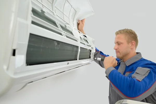 depositphotos_64643843-stock-photo-technician-repairing-air-conditioner img_histoire2-min
