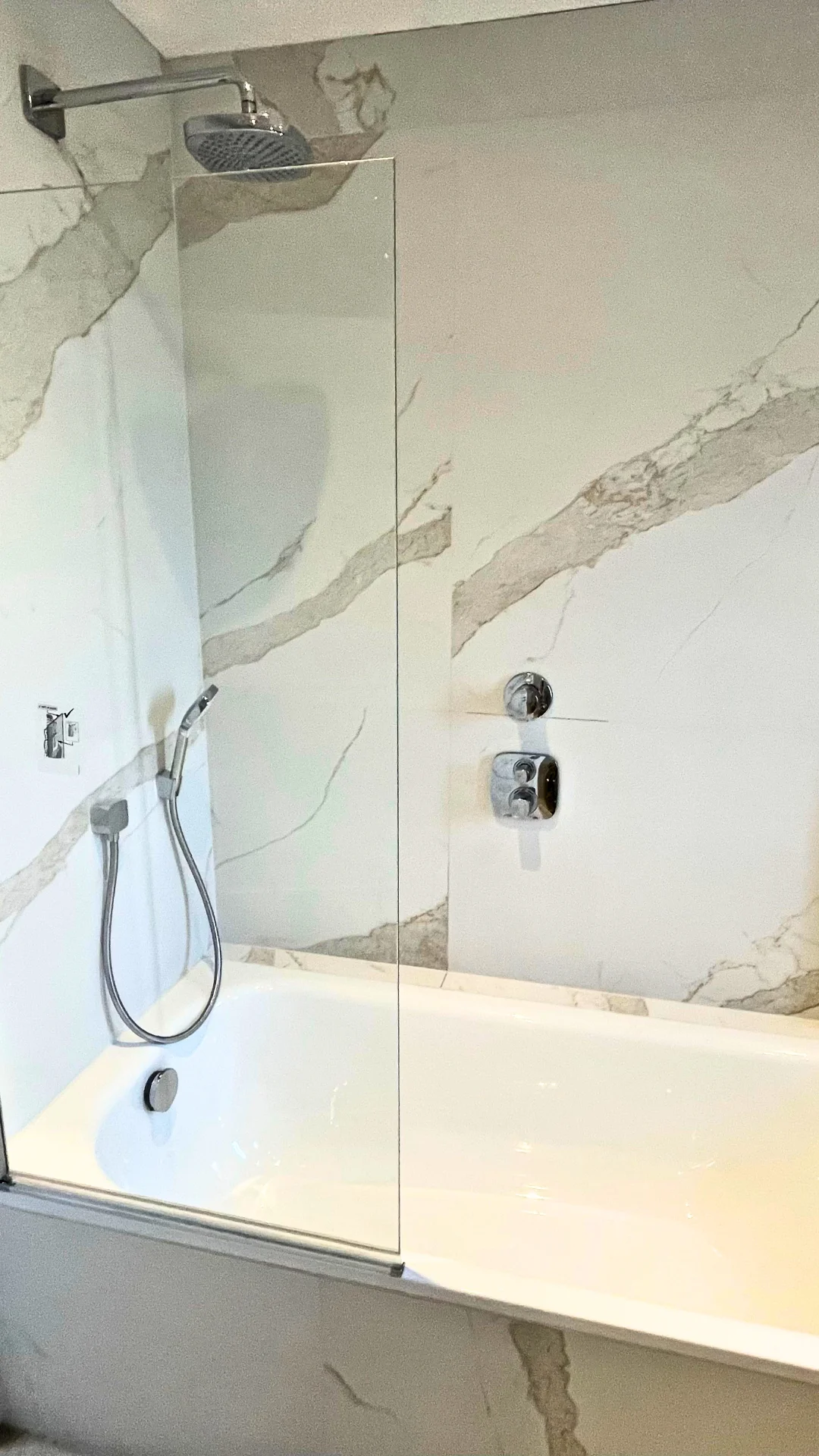 Baignoire avec paroi vitrée et douche intégrée dans une salle de bain moderne